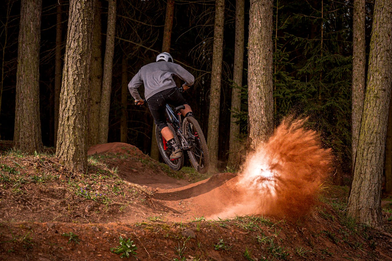 Man Riding Bicycle on Dirt Road